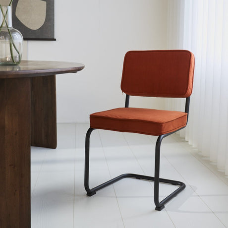 Sedia per sala da pranzo Remo in tessuto cannettato Dimehouse Ruggine LxPxH 56x55x52 Tessuto a coste Foto atmosferica vista frontale diagonale