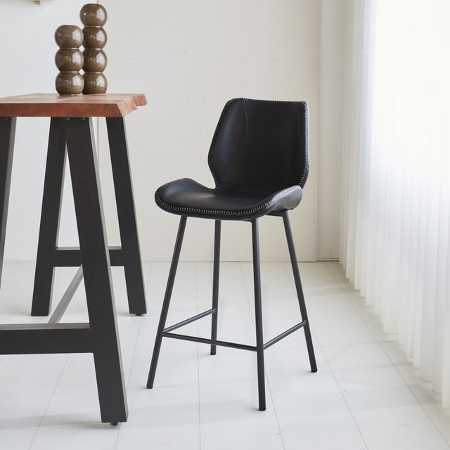 Sgabello da bar Beau in pelle artificiale Dimehouse Nero LxPxH 84x54x52 Ecopelle Foto atmosferica vista frontale diagonale